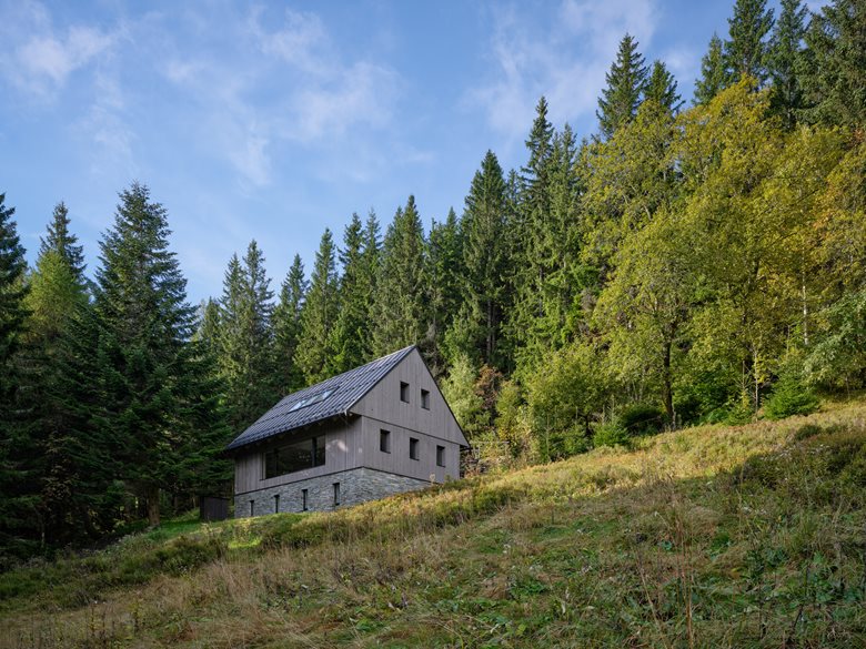 以石砌基座搭配木质覆层延续山地建筑风貌的度假木屋设计