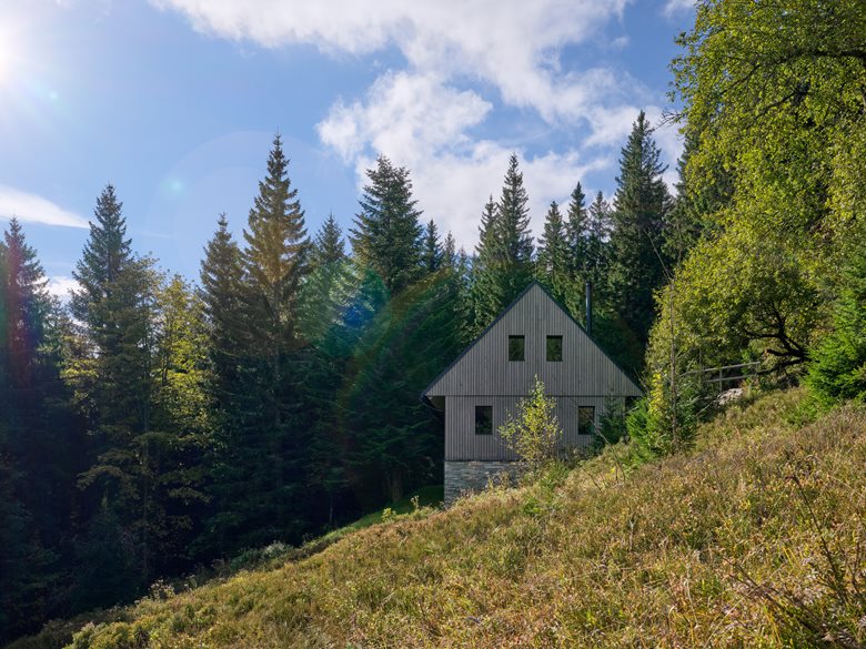 以石砌基座搭配木质覆层延续山地建筑风貌的度假木屋设计