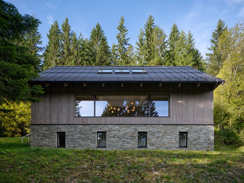 以石砌基座搭配木质覆层延续山地建筑风貌的度假木屋设计