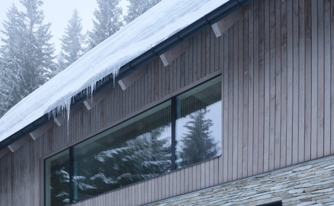 以石砌基座搭配木质覆层延续山地建筑风貌的度假木屋设计
